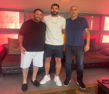 סאקר (באמצע) לאחר החתימה המחודשת